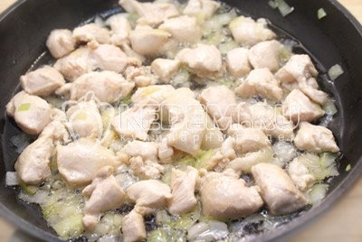 Разогреть в сковороде растительное масло и обжаривать курицу с луком, в течении 2-3 минут