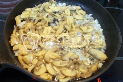 Обжарить на сковороде с оливковым маслом мелко нашинкованный лук и грибы 5-6 минут. Посолить и поперчить.