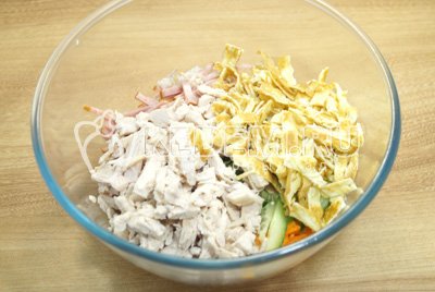 В миску с салатом добавить нашинкованные блинчики и куриное мясо.