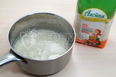 Рис промыть и высыпать в сотейник, добавить 300 миллилитров воды и поставить варить, помешивая, 10-12 минут, до готовности.