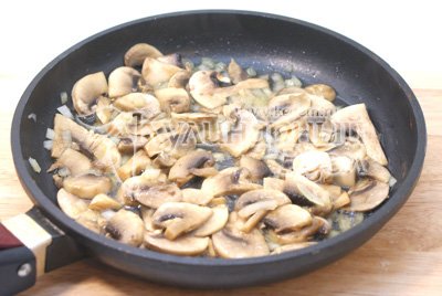 Мелко нашинкованную луковицу и ломтиками порезанные грибы обжарить на растительном масле 3-5 минут