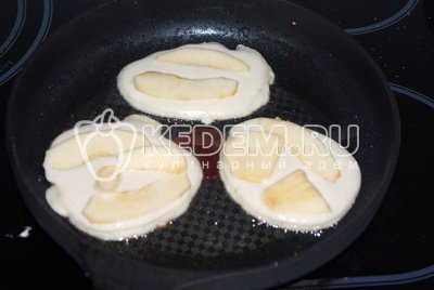 На хорошо разогреть сковородку с растительным маслом выкладываем ложкой тесто в форме оладий, сверху выкладываем несколько яблочных долек. Жарим до румяных корочек с двух сторон