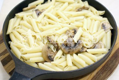 Выложить макароны в сковороду с грибами и заправить сливочным маслом. Перемешать и посолить