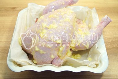 Обмазать курицу со всех сторон маслом с чесноком.