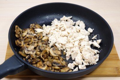 Мелко нашинковать куриное филе и добавить в сковороду к грибам, посолить и перемешать.