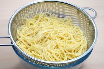 Отварные спагетти откинуть на дуршлаг и дать воде полностью стечь.