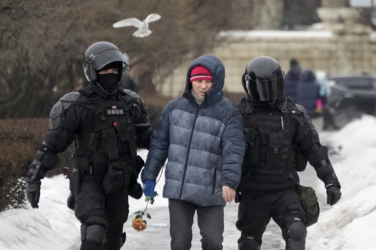 Бойцы спецподразделения российской полиции задерживают мужчину, пришедшего возложить цветы в честь...
